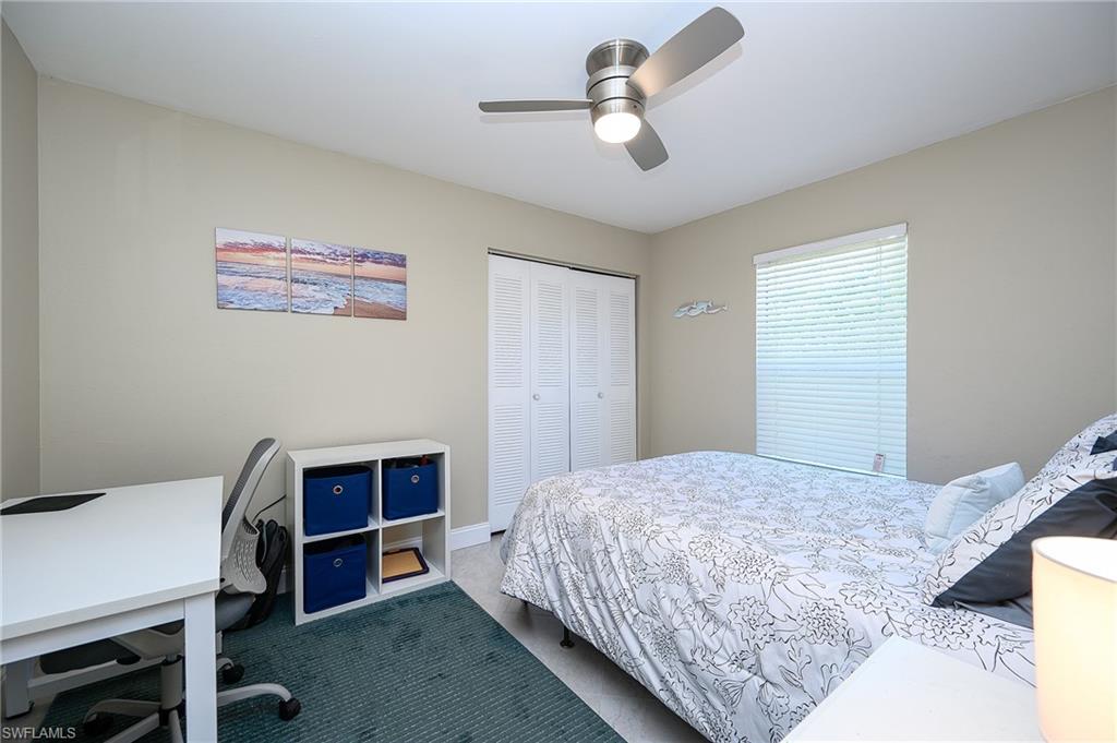 10058 Boca Circle Naples, FL 34109 - Photo 28 of 33 a bedroom with a bed and a chandelier