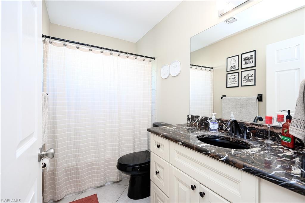 10058 Boca Circle Naples, FL 34109 - Photo 29 of 33 a bathroom with a sink and a mirror