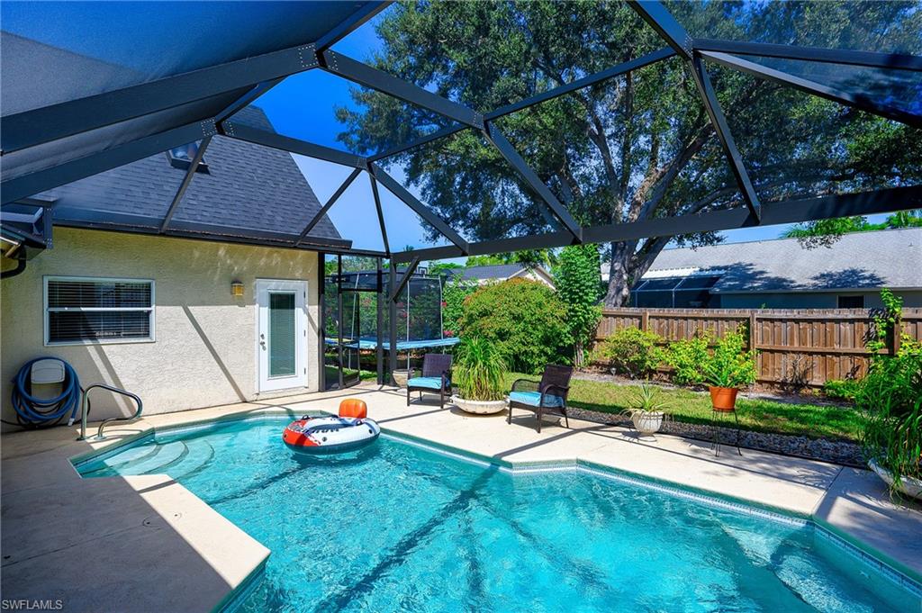 10058 Boca Circle Naples, FL 34109 - Photo 4 of 33 a backyard of a house with yard table and chairs