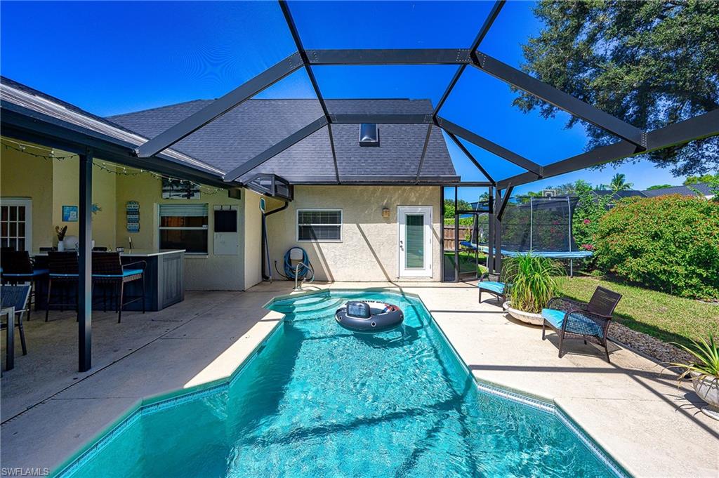 10058 Boca Circle Naples, FL 34109 - Photo 7 of 33 a view of a patio with table and chairs under an umbrella