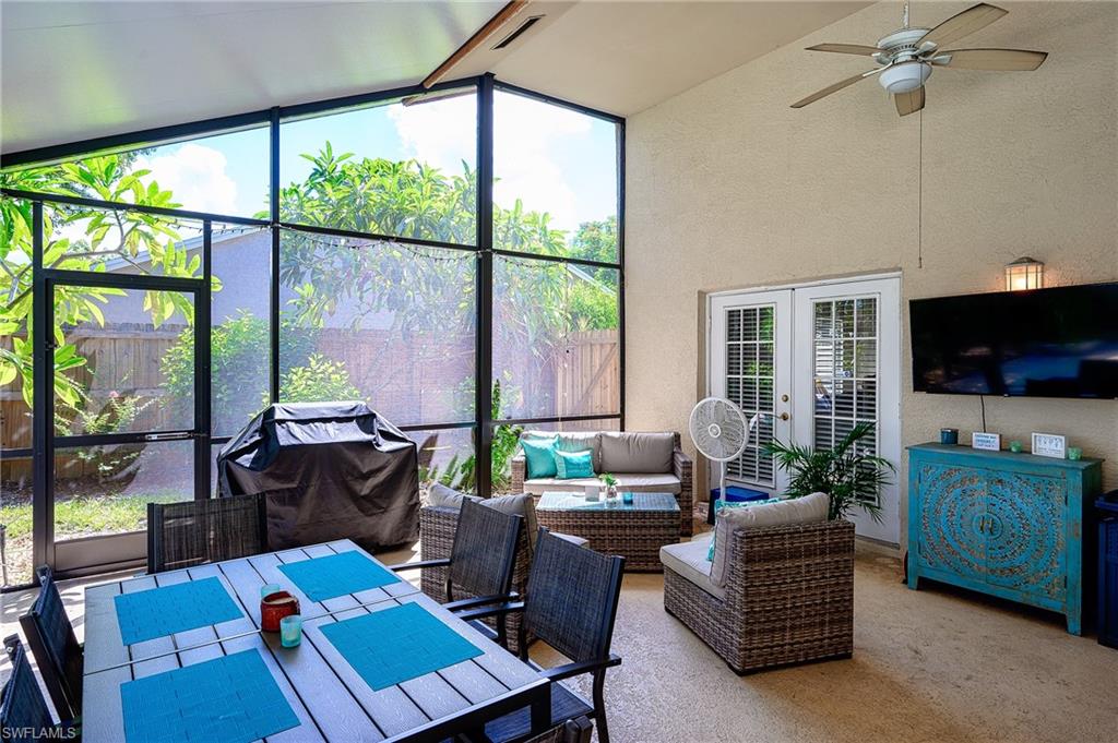 10058 Boca Circle Naples, FL 34109 - Photo 9 of 33 a living room with furniture a flat screen tv and a floor to ceiling window