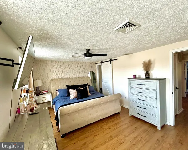 a bedroom with furniture and a flat screen tv