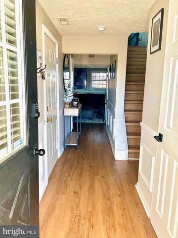 a view of a hallway with wooden floor and staircase