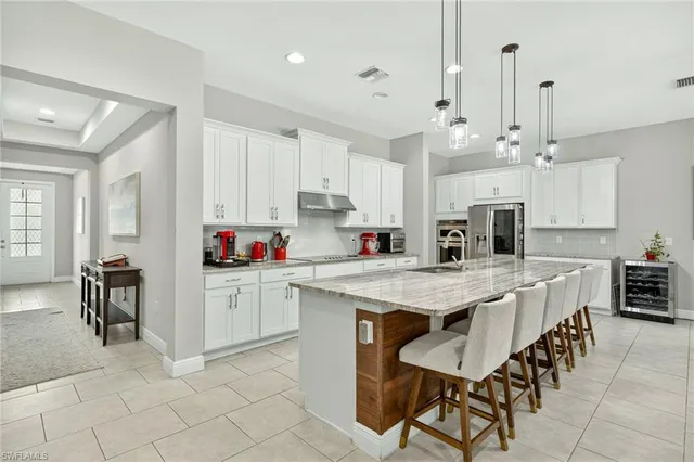 a kitchen with kitchen island granite countertop a table chairs sink and cabinets