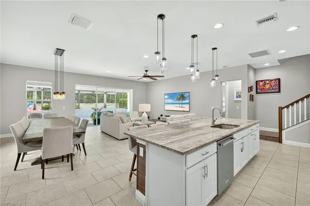 a dining hall with stainless steel appliances kitchen island a chandelier
