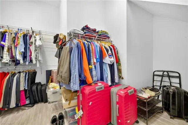 a view of walk in closet with clothes and shoes