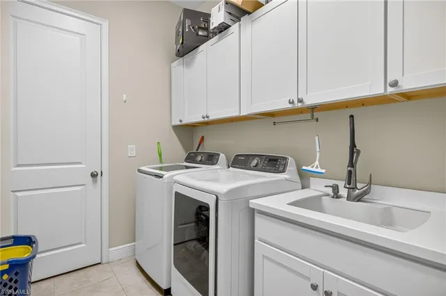 a utility room with sink dryer and washer