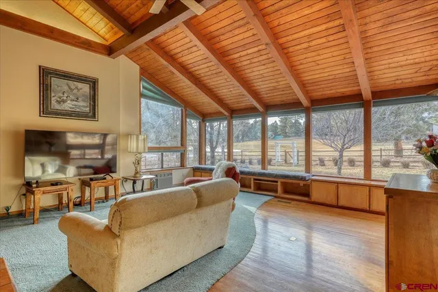 a living room with furniture with large windows