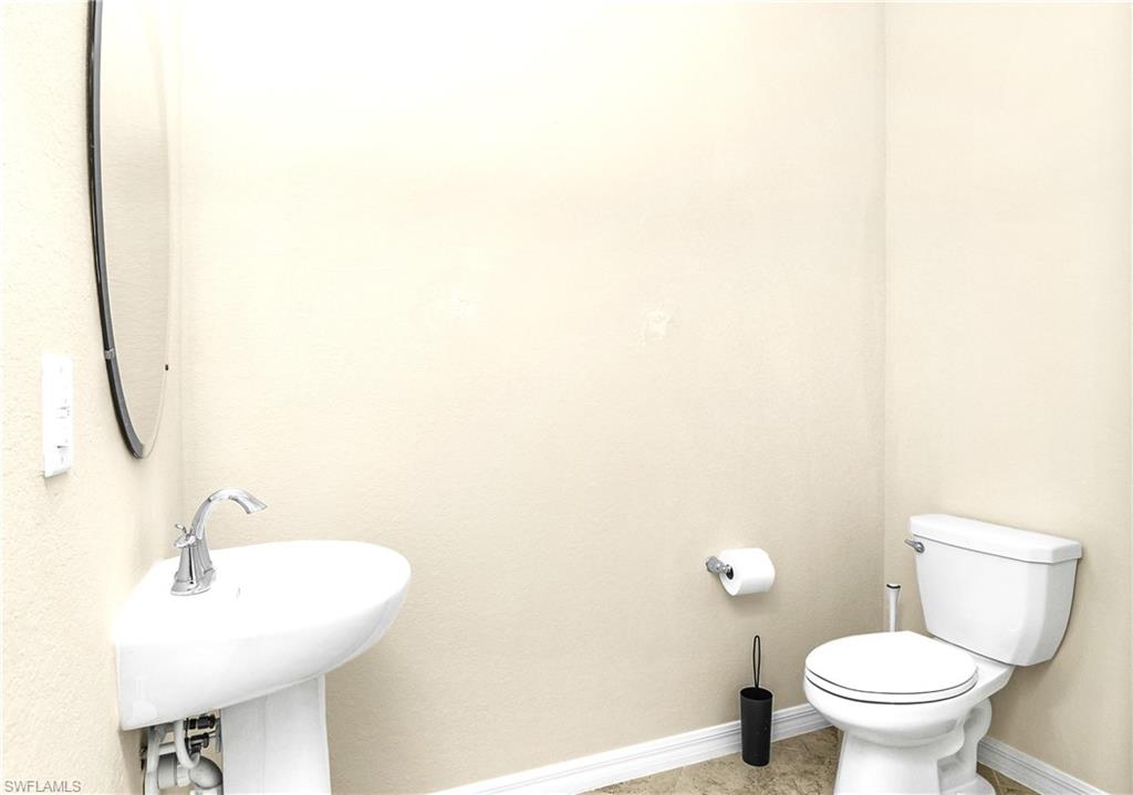 2754 Citrus Street Naples, FL 34120 - Photo 12 of 34 a bathroom with a sink a toilet and a mirror