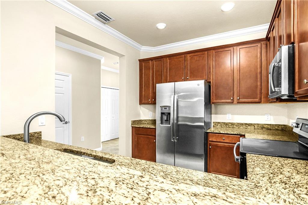 2754 Citrus Street Naples, FL 34120 - Photo 4 of 34 a kitchen with granite countertop a refrigerator and a stove top oven