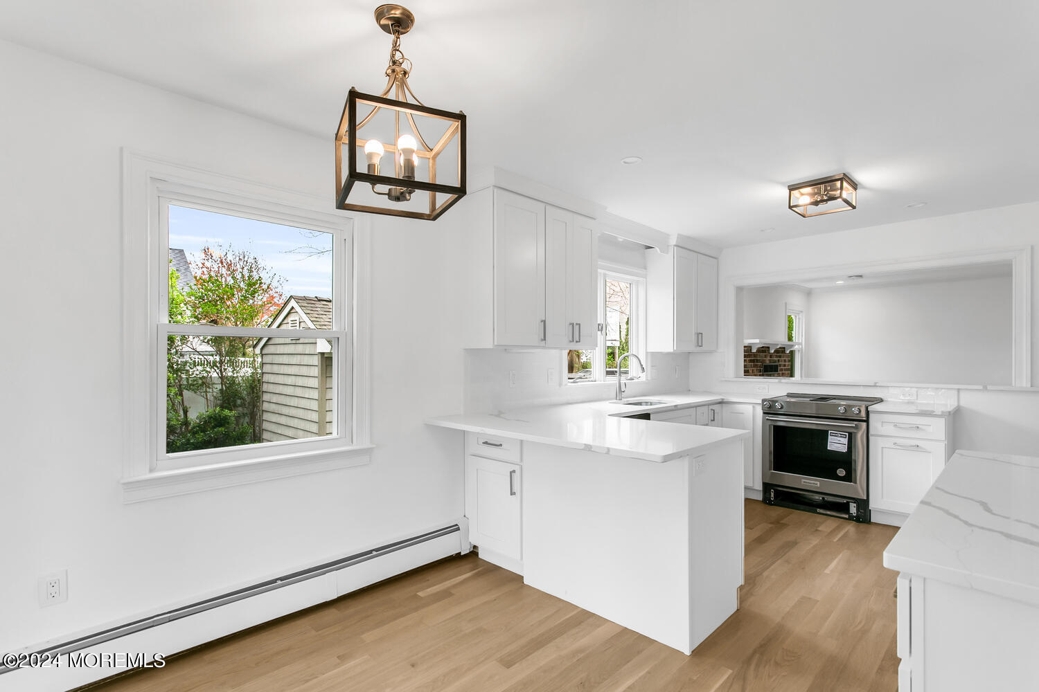 74 Ward Avenue Rumson, NJ 07760 - Photo 5 of 23 a kitchen with kitchen island a stove a sink a dining table and chairs with wooden floor