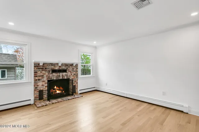 an empty room with fireplace and wooden floor