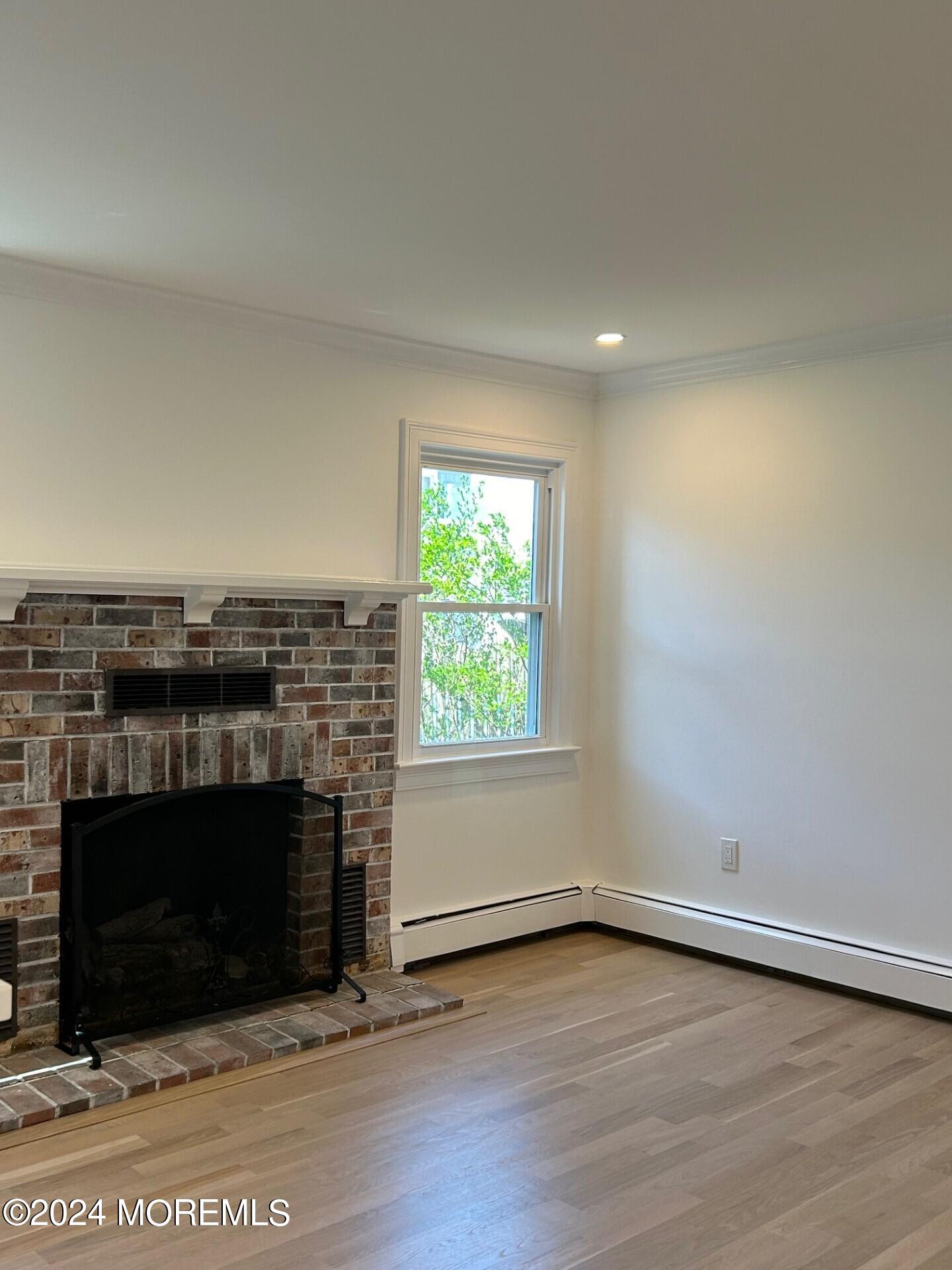74 Ward Avenue Rumson, NJ 07760 - Photo 10 of 23 an empty room with wooden floor and fireplace