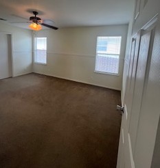 14909 Nuttall Drive Austin, TX 78724 - Photo 6 of 13 Empty room with dark carpet and ceiling fan