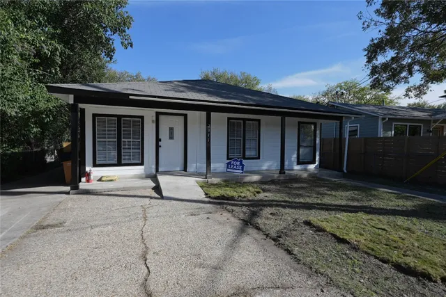 a view of a white house with a large window and plants