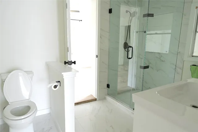 a bathroom with a toilet and a shower