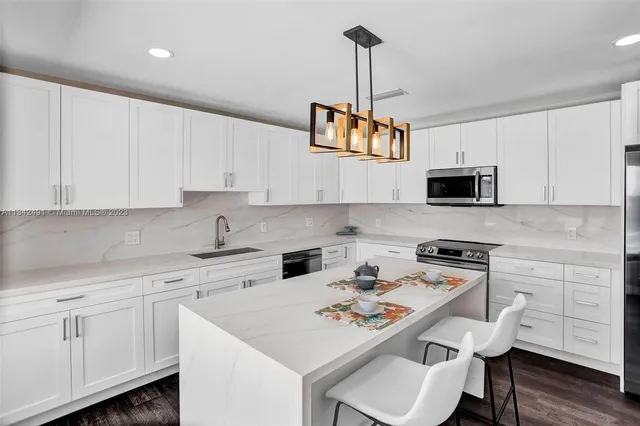 a kitchen with a sink a stove and chairs