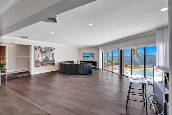 a living room with furniture floor to ceiling window and wooden floor