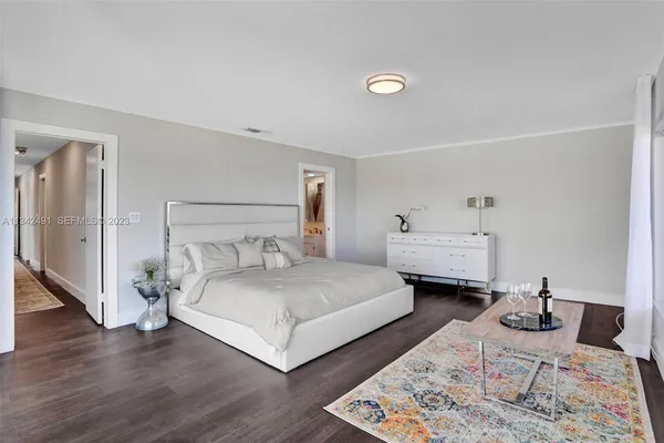 a bedroom with a bed and a wooden floor