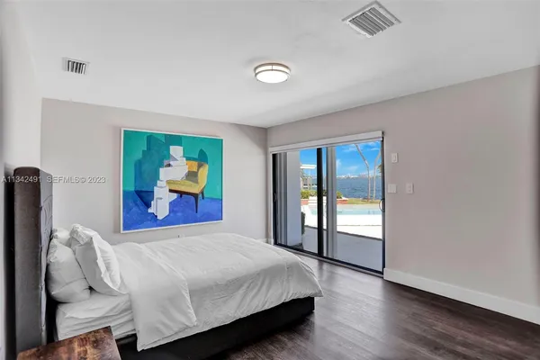 a bedroom with a bed and a painting on the wall