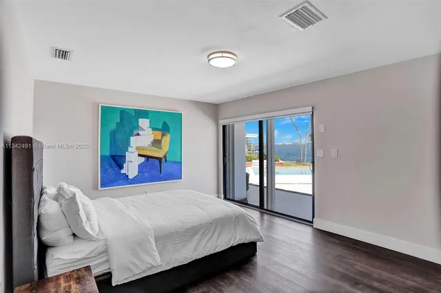 a bedroom with a bed and a painting on the wall