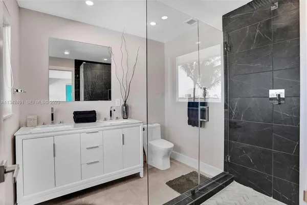a bathroom with a double vanity sink toilet and mirror