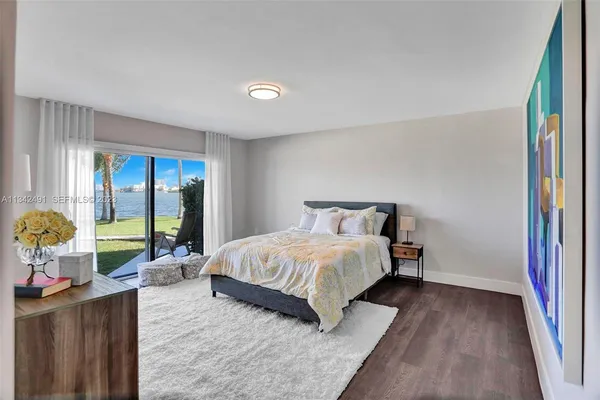 a bedroom with a bed and large windows