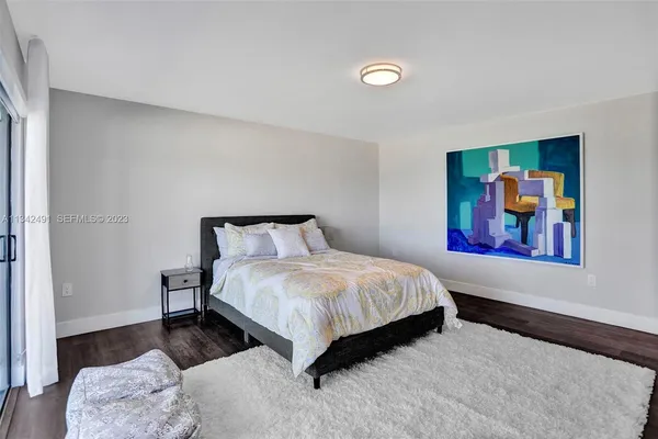 a bedroom with a bed and painting on the wall