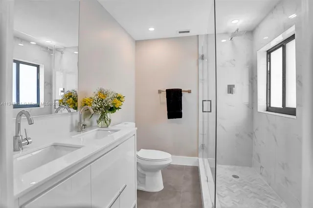 a bathroom with a sink a toilet and shower