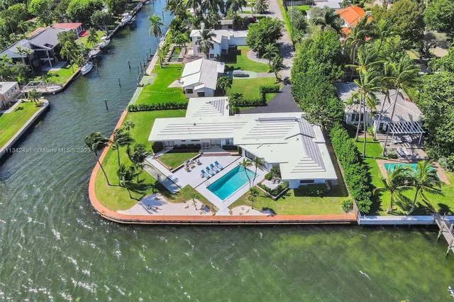 an aerial view of a house with swimming pool patio and lake view