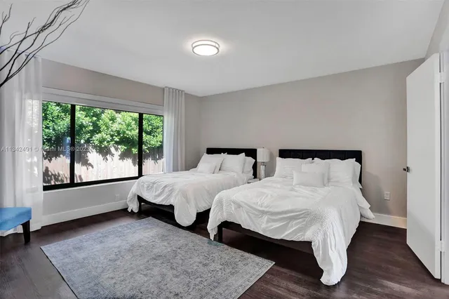 a spacious bedroom with two beds and large window