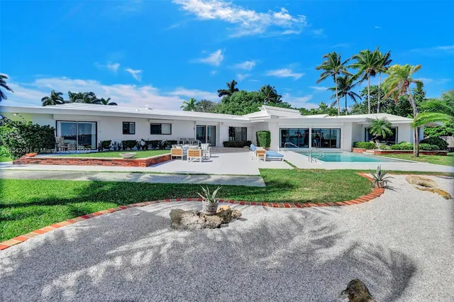 a view of a house with a yard patio and swimming pool