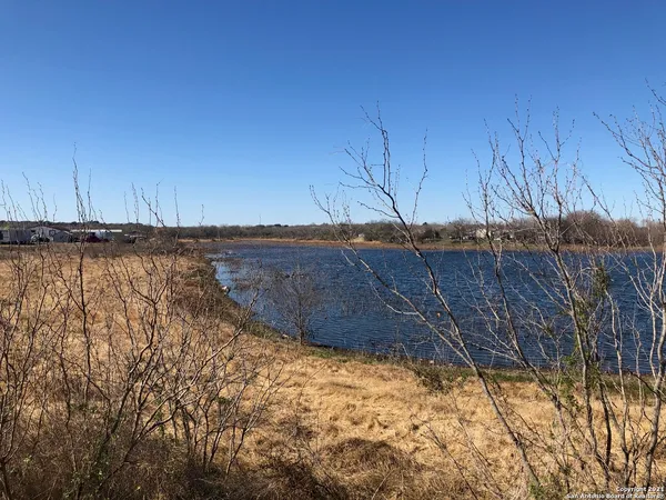 a view of a dry yard with wooden fence