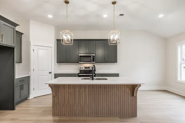 a kitchen with stainless steel appliances granite countertop a sink a refrigerator and a stove