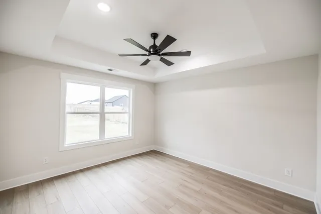 an empty room with windows and fan