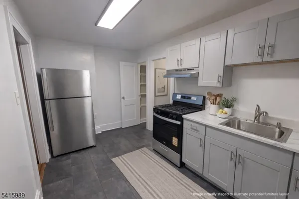 a kitchen with stainless steel appliances granite countertop a refrigerator sink and stove