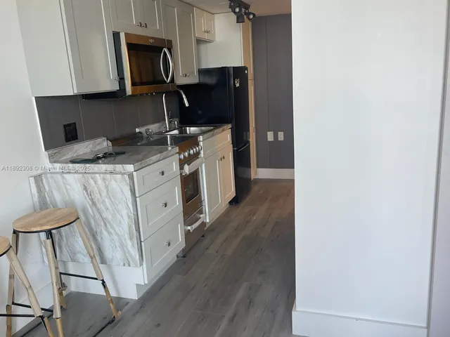 a kitchen with a sink appliances and cabinets