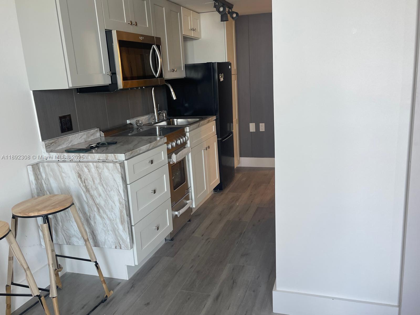 555 Northeast 15th Street, Unit 416 Miami, FL 33132 - Photo 8 of 13 a kitchen with a sink appliances and cabinets
