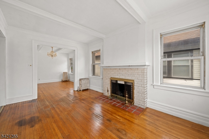116 Berkeley Avenue Bloomfield, NJ 07003 - Photo 2 of 13 a view of empty room with wooden floor and fireplace