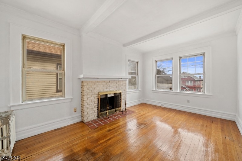 116 Berkeley Avenue Bloomfield, NJ 07003 - Photo 4 of 13 a view of an empty room with wooden floor and a window