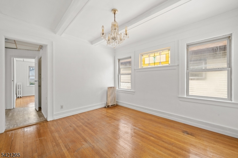 116 Berkeley Avenue Bloomfield, NJ 07003 - Photo 5 of 13 a view of an empty room with wooden floor and a window