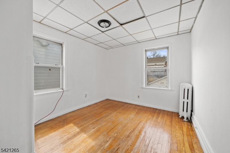 116 Berkeley Avenue Bloomfield, NJ 07003 - Photo 8 of 13 a view of empty room with wooden floor and fan