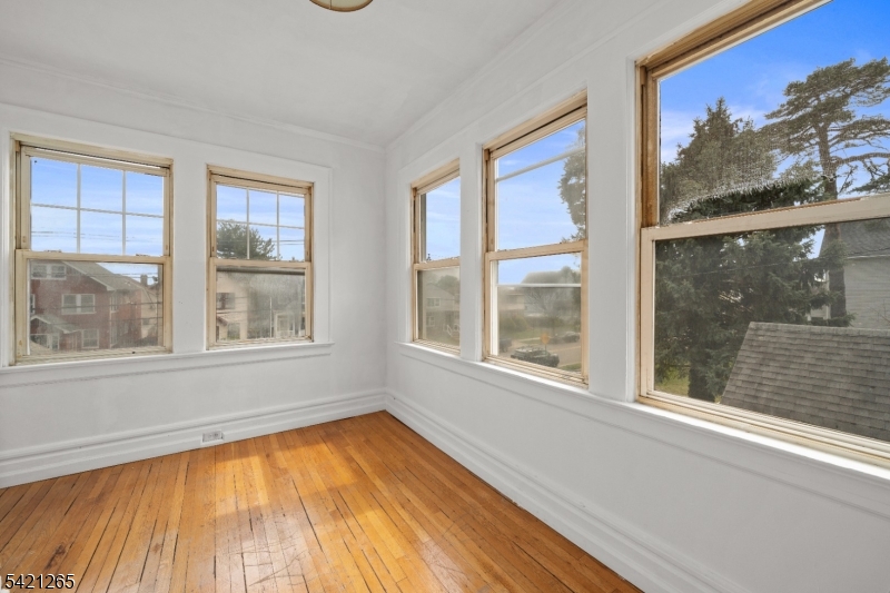116 Berkeley Avenue Bloomfield, NJ 07003 - Photo 10 of 13 a view of an empty room with a window and a kitchen view