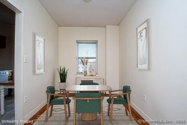 a room with a table chairs and a window