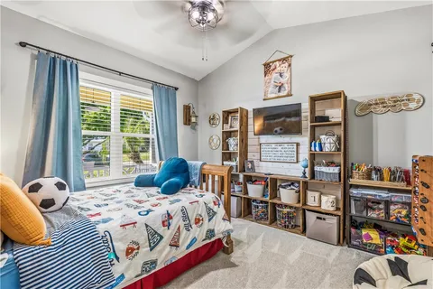 a bedroom with a bed a book shelf and a window