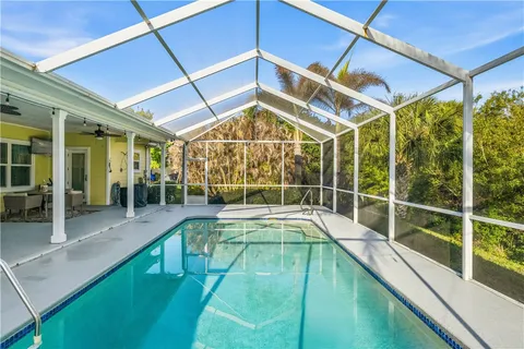 a swimming pool with glass windows and table