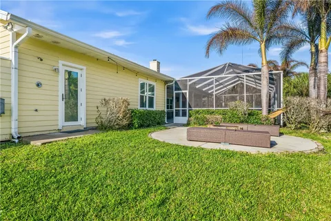 a front view of a house with a yard and potted plants