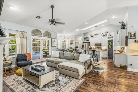 a living room with furniture a chandelier and a rug
