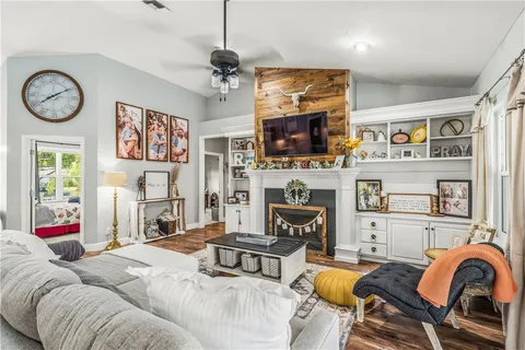 a living room with furniture a flat screen tv and a fireplace