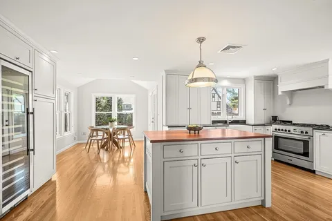 a kitchen with white cabinets and sink